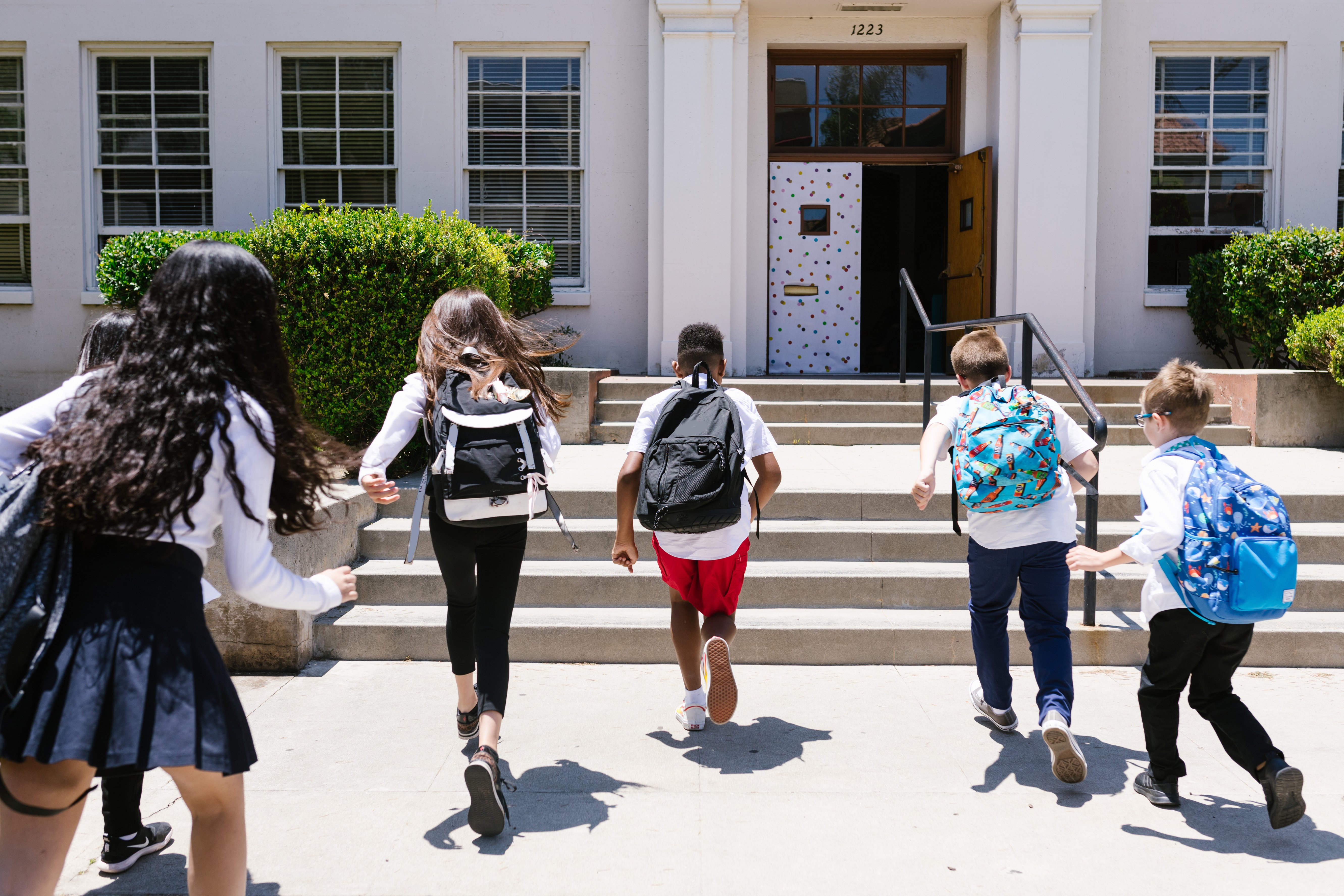 Back View Shot of Students Running to their Classroom